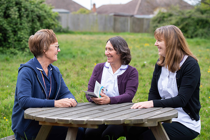 pharmacists laughing outside on hospital grounds